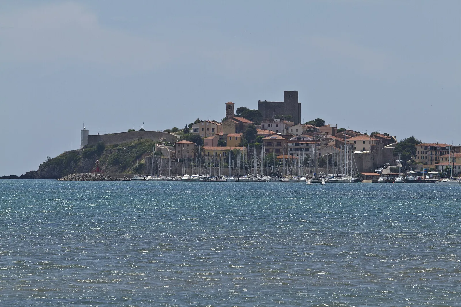 Il borgo di Talamone sul promontorio con la rocca aldobrandesca e il porto, visto dal golfo