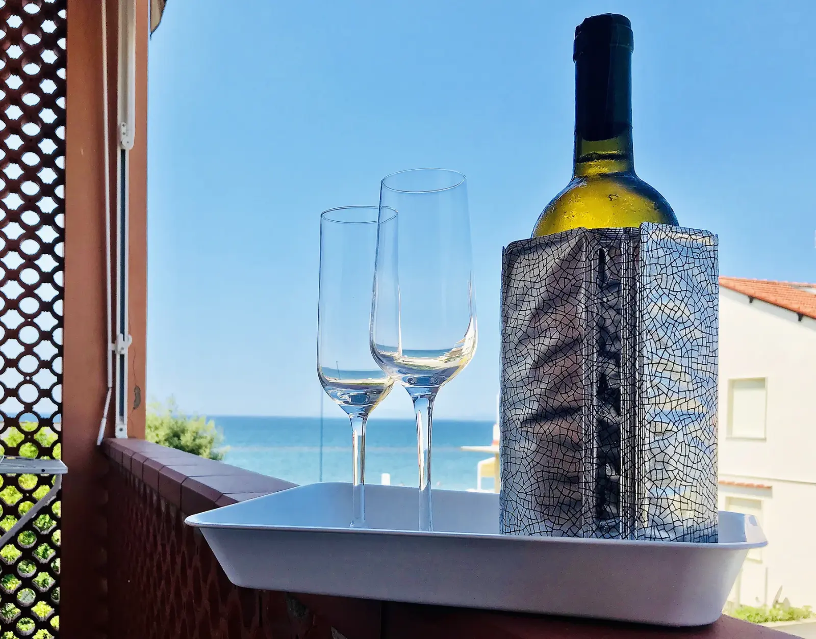 Bottiglia e calici davanti al mare